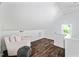 Cozy attic area featuring hardwood floors, a comfortable sofa, and natural light from the window at 218 Lafayette Rd, Raleigh, NC 27604