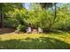 Lush backyard with two Adirondack chairs under the shade of mature trees provides a relaxing outdoor space at 218 Lafayette Rd, Raleigh, NC 27604