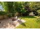 Backyard patio features brick pavers, Adirondack chairs, fire pit, privacy fence, and lush green foliage at 218 Lafayette Rd, Raleigh, NC 27604