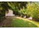 Backyard view features a storage shed and two Adirondack chairs under the shade of mature trees at 218 Lafayette Rd, Raleigh, NC 27604