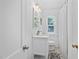 Bathroom with marble-top vanity, decorative mirror, and ample natural light from the window at 218 Lafayette Rd, Raleigh, NC 27604