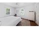 Bright bedroom featuring hardwood floors, two windows, and a dresser in a light and airy setting at 218 Lafayette Rd, Raleigh, NC 27604