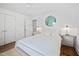 Clean bedroom featuring white walls, hardwood floors, a white metal frame bed, and plenty of natural light at 218 Lafayette Rd, Raleigh, NC 27604