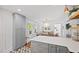 Open kitchen with gray cabinets, quartz countertops, stainless hardware, and decorative pendant lighting over the dining area at 218 Lafayette Rd, Raleigh, NC 27604