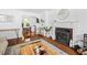 Cozy living room with hardwood floors, fireplace, and views to the dining area at 218 Lafayette Rd, Raleigh, NC 27604