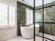 Modern bathroom featuring a standalone tub, decorative green tile and glass enclosed shower at 2212 Oxford Hills Dr, Raleigh, NC 27608