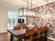 Dining room features a rustic table, designer wallpaper, and view of the living area at 2212 Oxford Hills Dr, Raleigh, NC 27608