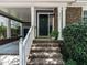 Charming brick home featuring a covered portico, black front door and landscaped entryway at 2212 Oxford Hills Dr, Raleigh, NC 27608