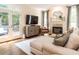 Cozy living room with fireplace, neutral décor, and French doors leading to the outdoor space at 2212 Oxford Hills Dr, Raleigh, NC 27608