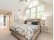 Bright main bedroom boasts large windows, patterned duvet, and ensuite bathroom access at 2212 Oxford Hills Dr, Raleigh, NC 27608