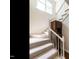 Carpeted staircase with a wooden banister and unique built-in storage creates a stylish transition between floors at 2212 Oxford Hills Dr, Raleigh, NC 27608