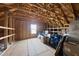 Unfinished attic space with exposed beams, insulation, and a window providing natural light at 2412 Averon Dr, Fuquay Varina, NC 27526