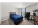 Bedroom features a plush blue bed, neutral carpeting, and ample natural light from the window at 2412 Averon Dr, Fuquay Varina, NC 27526