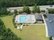 Aerial view showcases the community pool with lounge chairs, umbrellas, and a clubhouse in a well-kept area at 2412 Averon Dr, Fuquay Varina, NC 27526