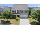 Well-maintained two-story home with a large driveway, manicured lawn, and mature trees at 2412 Averon Dr, Fuquay Varina, NC 27526