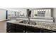 Gourmet kitchen featuring granite counters, stainless steel sink, and seamless flow to living area at 2412 Averon Dr, Fuquay Varina, NC 27526