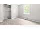 Bright bedroom featuring neutral carpet, a window offering natural light, and a closet with built-in shelving at 250 Dixon Rd, Graham, NC 27253