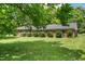 Charming brick home features a well-manicured lawn and mature trees, offering a serene and inviting curb appeal at 250 Dixon Rd, Graham, NC 27253