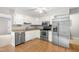 Bright kitchen boasts white cabinets, stainless steel appliances, and laminate flooring for a clean, modern look at 250 Dixon Rd, Graham, NC 27253