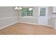 Bright dining room featuring wood floors, chair rail, modern lighting, and natural light at 2708 Sundial Cir, Durham, NC 27704
