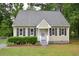 Charming tan home with a cozy front porch, dark shutters and well-maintained landscaping at 2708 Sundial Cir, Durham, NC 27704