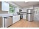 Modern kitchen featuring stainless steel appliances, granite countertops, and sleek white cabinetry at 2708 Sundial Cir, Durham, NC 27704
