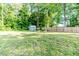 Large, grassy backyard with a wooden fence, a shed, and mature trees at 2802 Bingham Dr, Mebane, NC 27302