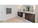 Well-lit bathroom showcasing a double vanity with dark cabinetry and tiled floors at 2802 Bingham Dr, Mebane, NC 27302