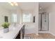Bathroom with dual sink vanity, soaking tub beneath a window, and glass-enclosed shower at 2802 Bingham Dr, Mebane, NC 27302