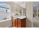 Well-lit bathroom featuring a wood vanity, white countertop, large mirror, and a view through a window at 2821 Corbett Grove Dr, Raleigh, NC 27604