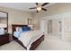 Spacious main bedroom with ensuite bathroom, large bed, fan, and neutral carpet and paint at 2821 Corbett Grove Dr, Raleigh, NC 27604