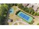 Aerial view of well-maintained community tennis courts with blue and green surfaces, surrounded by lush greenery and walkways at 2821 Corbett Grove Dr, Raleigh, NC 27604