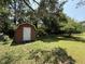 View of backyard shed with a white door, situated on a level lot with mature trees at 2909 Sprucewood Dr, Durham, NC 27707