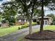 Charming single-story home with well-manicured lawn, featuring vibrant shrubbery and mature trees at 2909 Sprucewood Dr, Durham, NC 27707