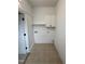 Bright laundry room features tile floor and storage shelf at 2909 Sprucewood Dr, Durham, NC 27707