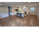 Open-concept living room with hardwood floors adjacent to modern kitchen with island seating at 2909 Sprucewood Dr, Durham, NC 27707