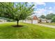 Landscaped front yard with lush green grass, a mature tree, and a brick home at 3027 Maple # T1, Burlington, NC 27215