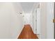 Hallway featuring neutral walls, wood flooring, and white trim, connecting different areas of the home at 3027 Maple # T1, Burlington, NC 27215