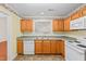 This traditional kitchen features wood cabinets, tiled floor, and appliances in a functional layout at 3027 Maple # T1, Burlington, NC 27215