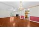 Open-concept living room with hardwood floors, access to the kitchen, a fireplace, and doors to the exterior at 3027 Maple # T1, Burlington, NC 27215