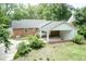 Backyard view featuring a covered patio, lush greenery, and detached garage at 303 Spring St, Louisburg, NC 27549