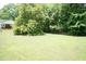 Expansive green backyard with lush trees, providing a private and serene setting at 303 Spring St, Louisburg, NC 27549