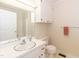 Bright bathroom featuring a single sink vanity, mirror, and wall cabinets for storage at 303 Spring St, Louisburg, NC 27549