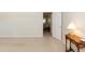 Bedroom with doorway and a classic wooden side table and neutral walls at 303 Spring St, Louisburg, NC 27549