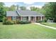 A single-story brick home with a convenient ramp and lush landscaping provides accessible living at 303 Spring St, Louisburg, NC 27549