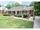 A single-story brick home with a convenient ramp and lush landscaping provides accessible living at 303 Spring St, Louisburg, NC 27549