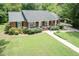 Charming home with lush lawn, mature trees, and convenient handicap access ramp at 303 Spring St, Louisburg, NC 27549