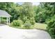 Landscaped front yard with mature trees and a covered front entrance to the house at 303 Spring St, Louisburg, NC 27549