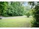 Green front yard with mature trees; serene and inviting outdoor space at 303 Spring St, Louisburg, NC 27549