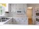 Bright kitchen features white cabinets, stainless steel sink, and modern appliances at 303 Spring St, Louisburg, NC 27549